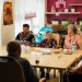 Seniors enjoying a meal in a nursing home dining room with caregivers in Karviná, Czechia.